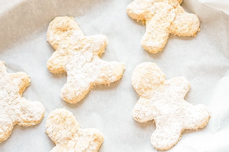 gingerbread man dog treats on a parchment lined cookie sheet