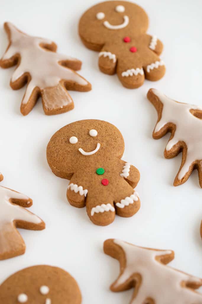 gingerbread men and christmas tree cookies on a white surface