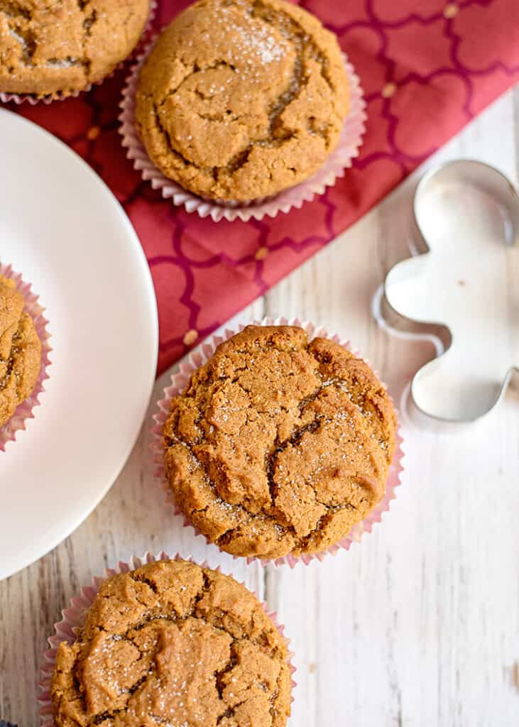 overhead photo of muffins on a white surface with a maroon fabric