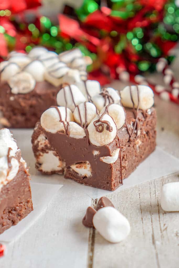 fudge on pieces of parchment paper with red and green ribbon behind it