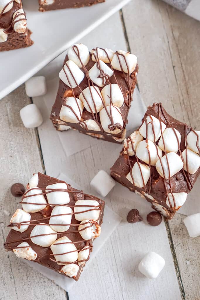 overhead photo of hot cocoa fudge on wax paper and mini marshmallows around the fudge