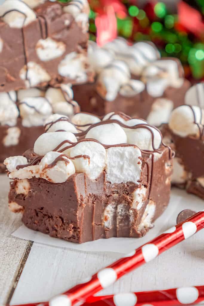 fudge on a piece of wax paper with red straws in front of it and a bite taken out of the fudge