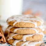 a shot of the side of a stack of cookies with a glass of milk behind it