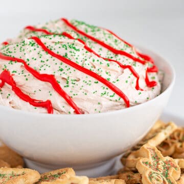 bowl of dip with holiday cookies around the dip and a white background