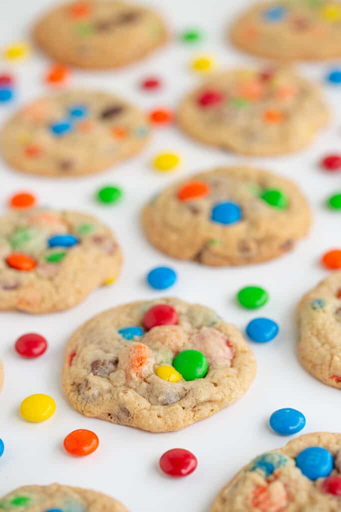 cookies on a white surface with M&M candies around the cookies