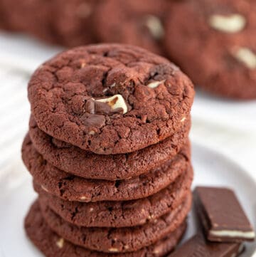 Photo focusing on the top of a stack of cookies that are sitting on a white plate with a green and white fabric under them