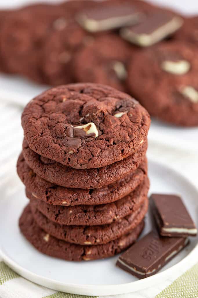 Photo focusing on the top of a stack of cookies that are sitting on a white plate with a green and white fabric under them