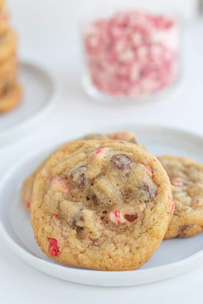 white plate with a cookie propped up on other cookies