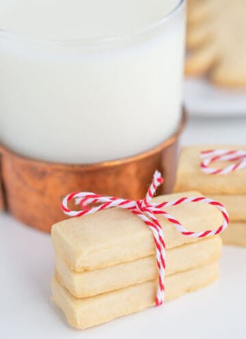 shortbread cookies tied with bakers twin with a glass of milk behind it