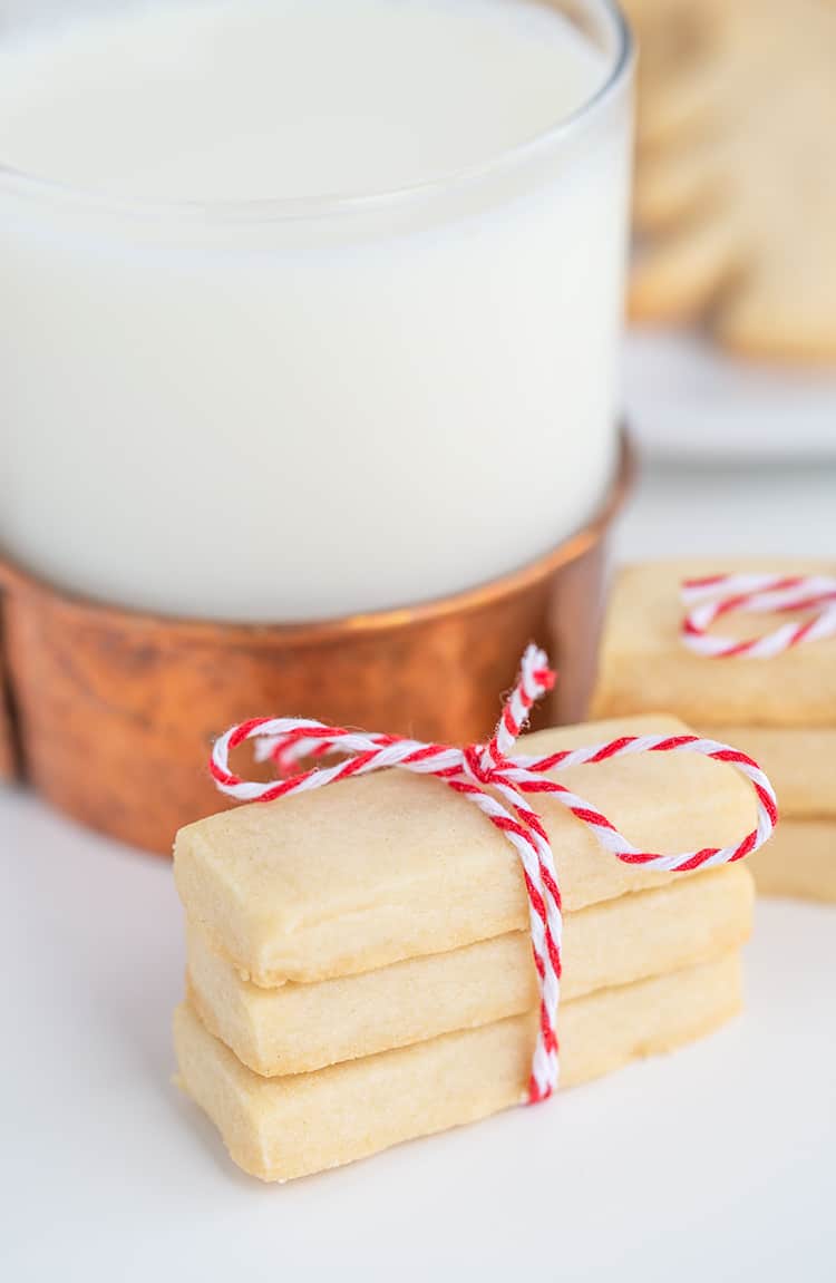 shortbread cookies tied with bakers twin with a glass of milk behind it