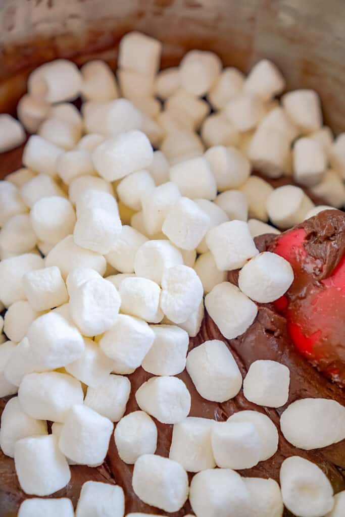 marshmallows being added to a bowl of ingredients