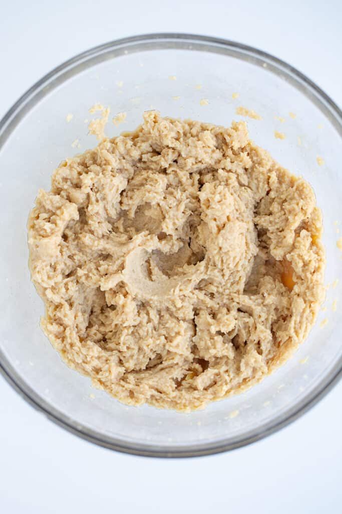 wet ingredients creamed in a glass mixing bowl on a white surface