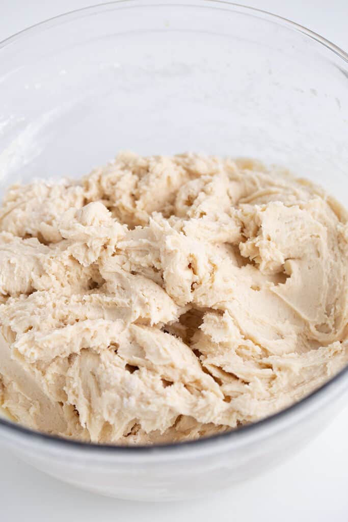 glass bowl with sugar cookie dough in it on a white surface