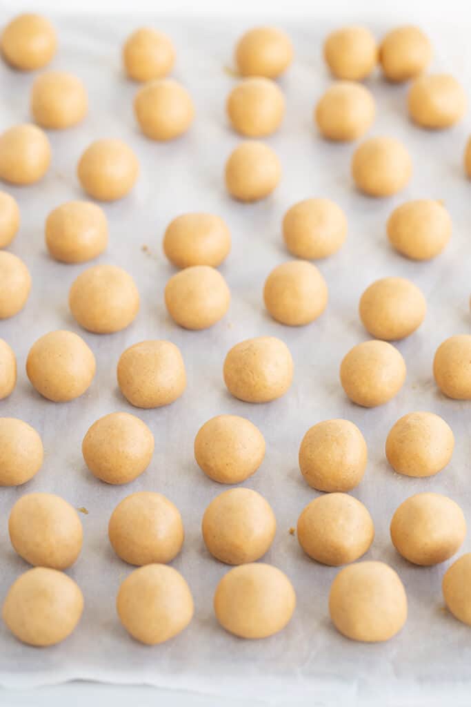 peanut butter balls rolled until smooth and placed on a parchment lined cookie sheet