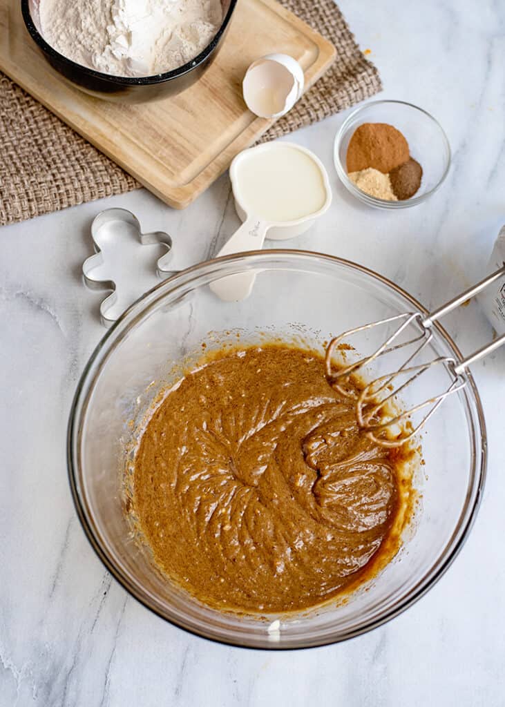 wet ingredients creamed in a glass bowl with dry ingredients around the bowl