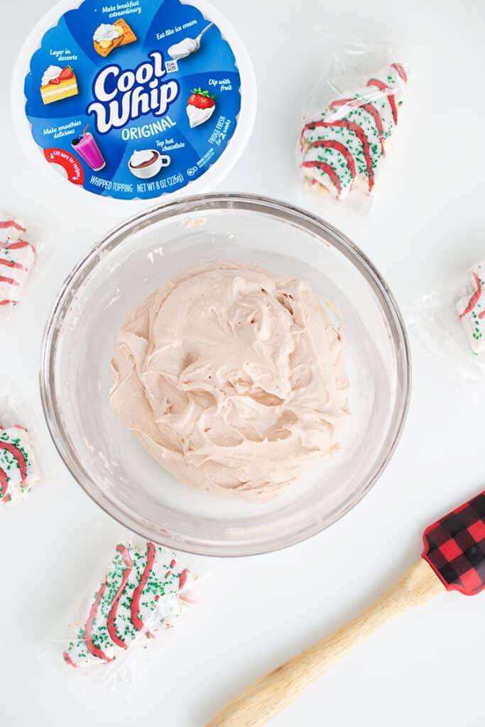 overhead photo of a glass bowl of cake mixture with christmas tree cakes around the bowl