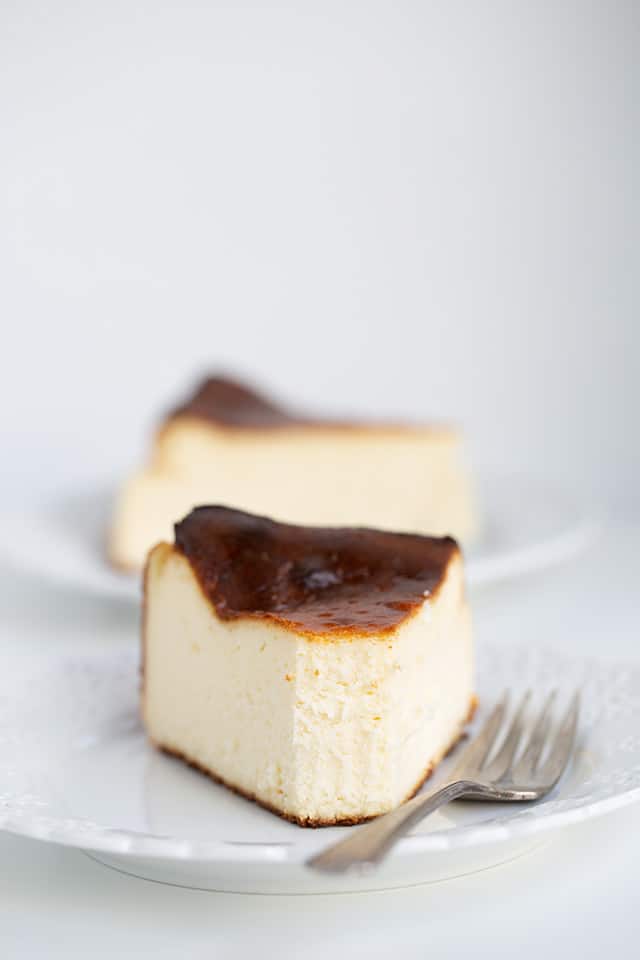 slice of cheesecake on a plate with a fork and a bite taken from it