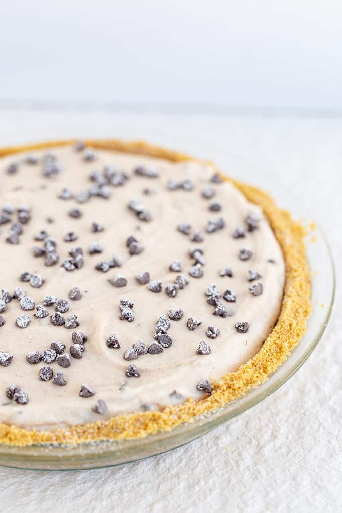 pie in a glass plate on a textured white surface