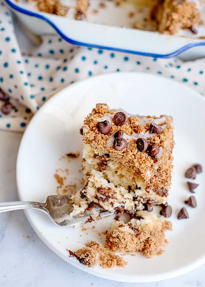 coffee cake on a white plate with chocolate chips and a fork