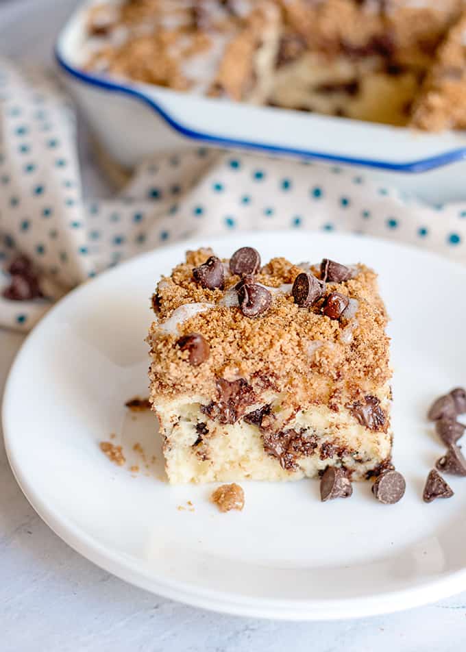 a white plate with a slice of coffee cake on it and chocolate chips