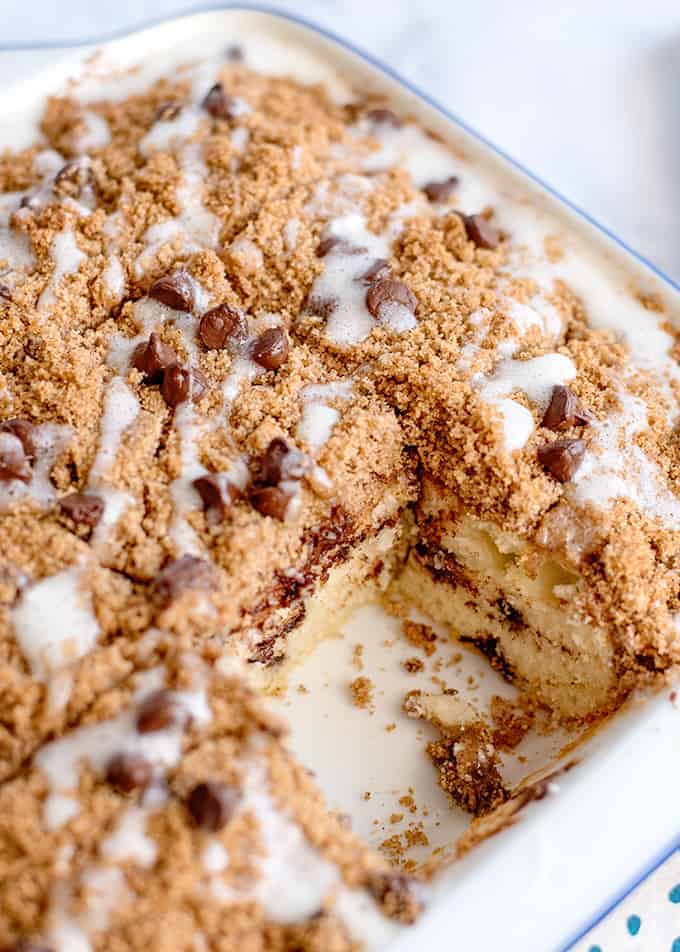 coffee cake in a white square pan with a piece missing