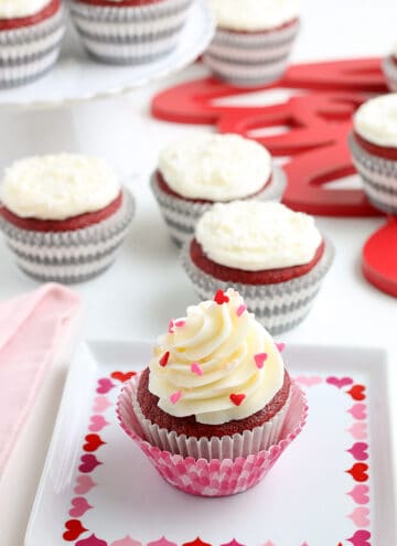 a cupcake on a square plate with hearts on it