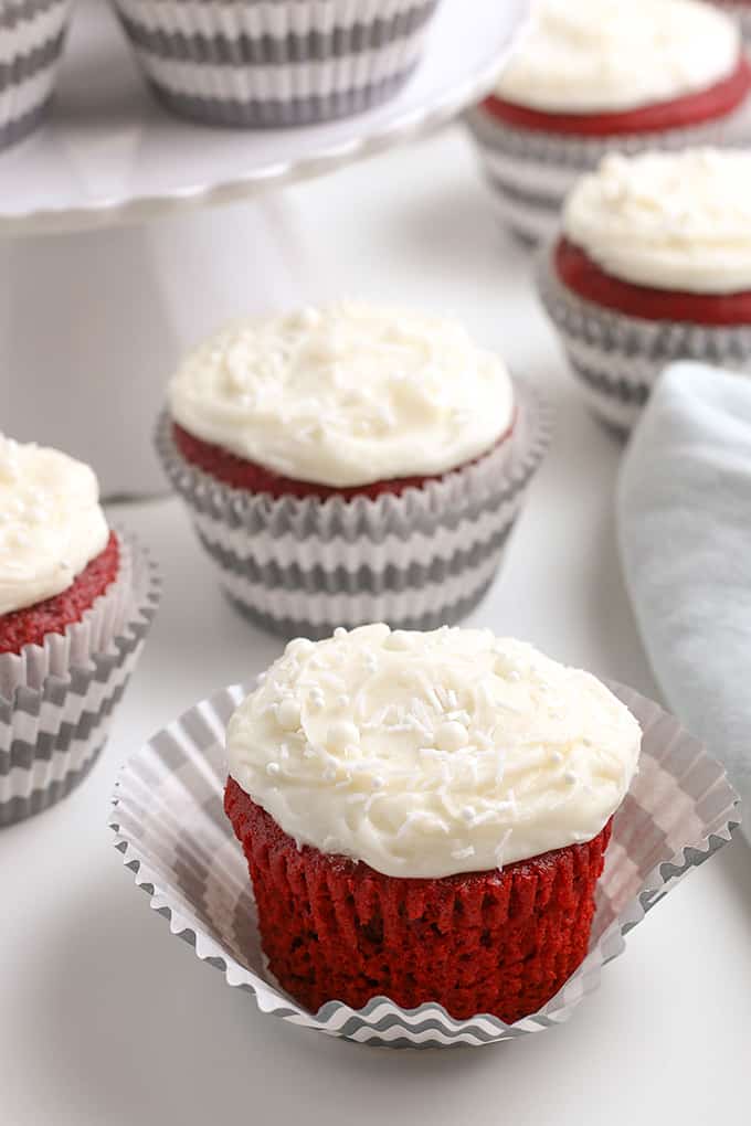 red velvet cupcakes with the cupcake wrapper peeled away on a white background
