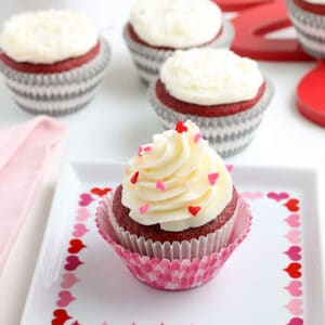 square image of a valentine's day themed red velvet cupcake on a white square plate