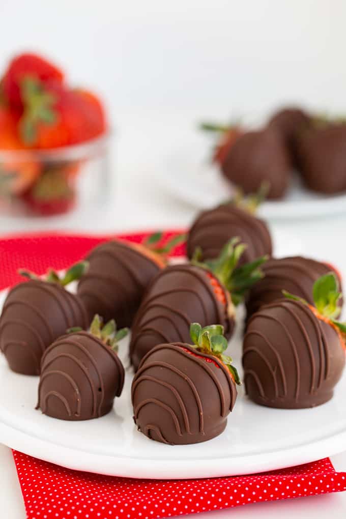 Chocolate Covered Strawberries on a white plate with a red linen under it