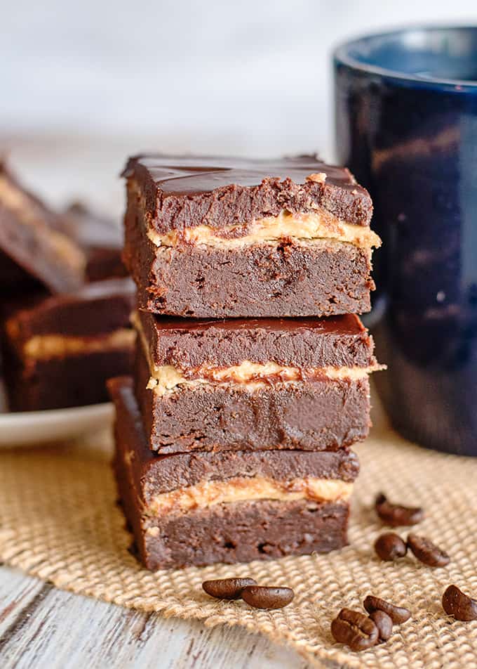 a stack of brownies on a piece of burlap with a mug behind it