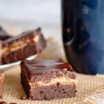 a brownie square on a piece of burlap with a blue mug behind it