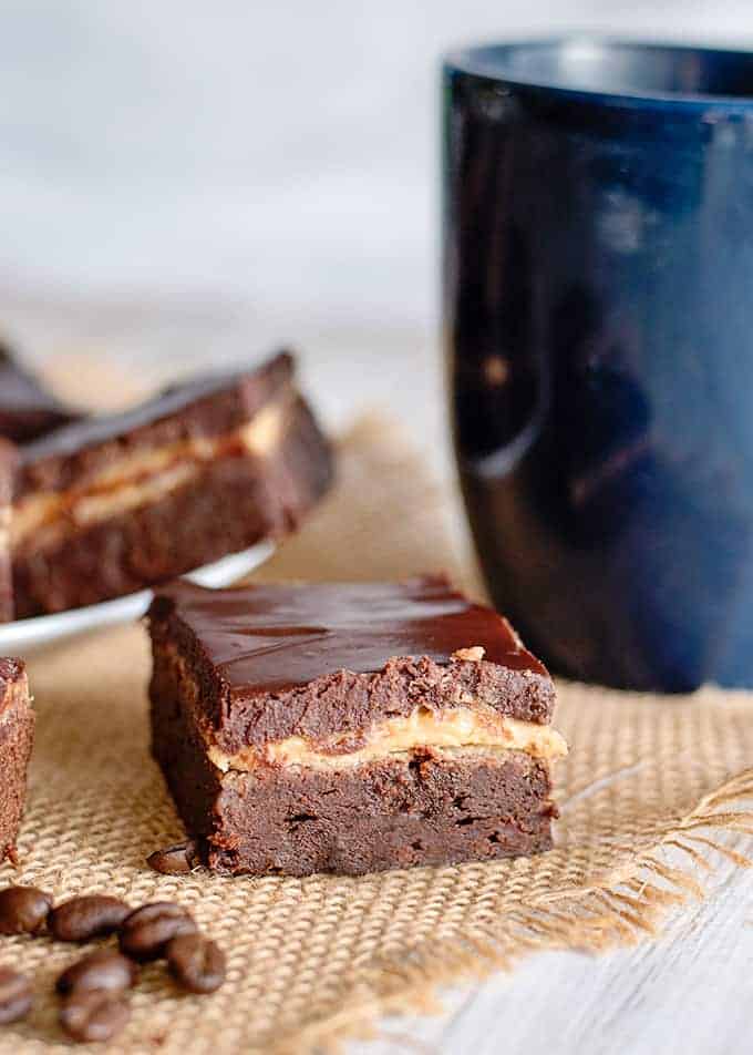 a brownie square on a piece of burlap with a blue mug behind it