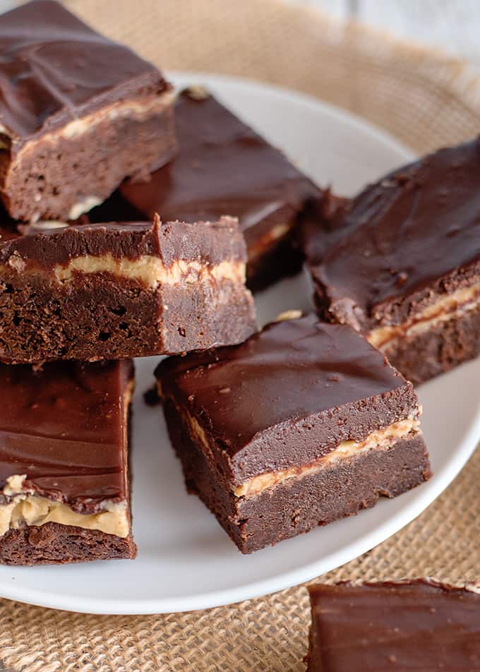 a white plate full of brownies with burlap under plate