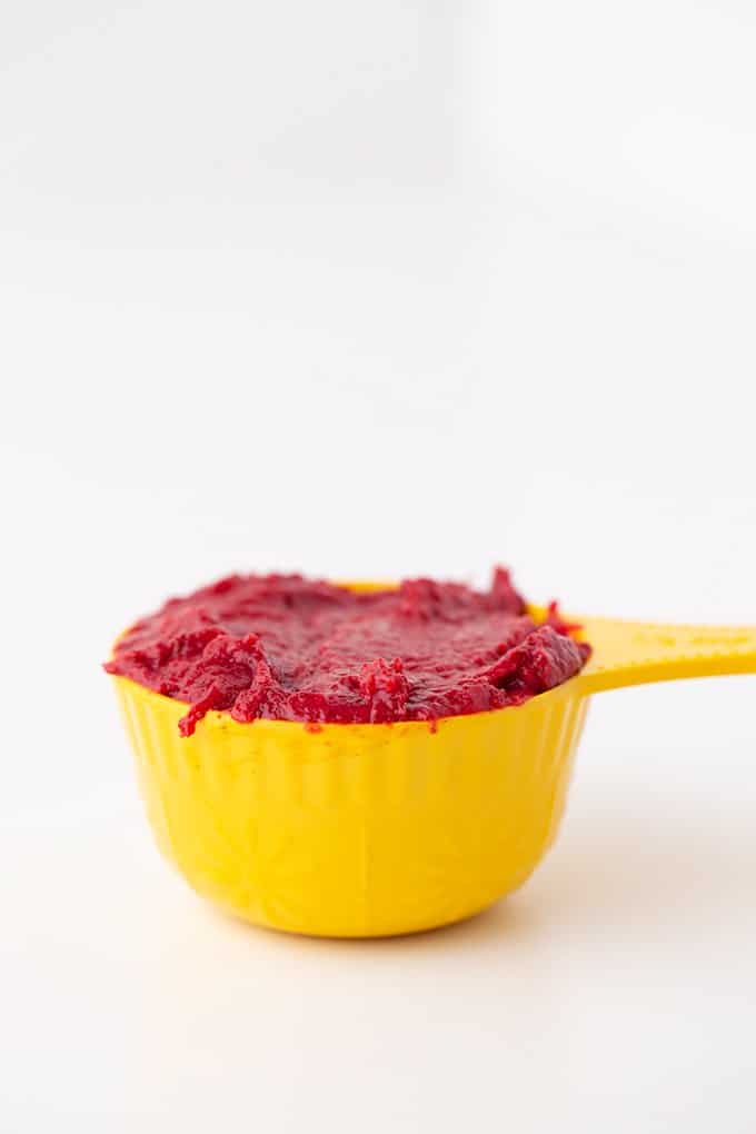 strawberry puree in a yellow ½ cup measuring cup