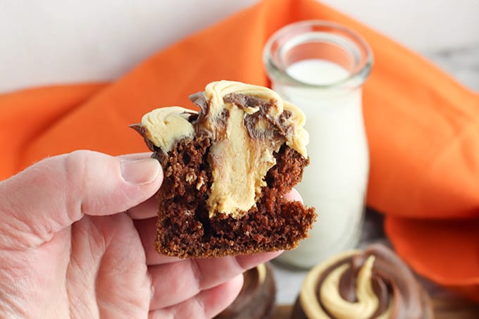 holding a cupcake that's been cut in half showing the peanut butter filling