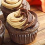 sqaure image of chocolate cupcakes with a swirl of chocolate peanut butter frosting on a wooden cutting board