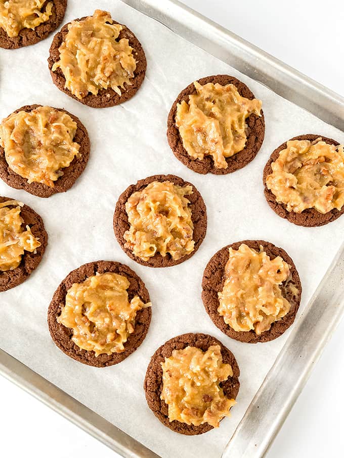 baking tray full of chocolate cookies with coconut pecan frosting on top