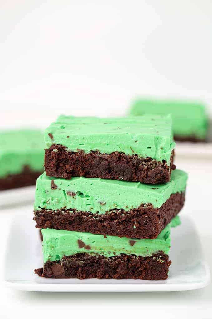 a stack of brownies on a white square plate