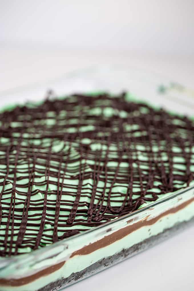 glass pan full of layer dessert on a white background