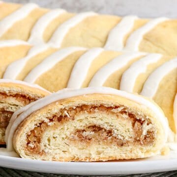 zoomed in image of a slice of nut roll on a white plate with a gray placemat under it