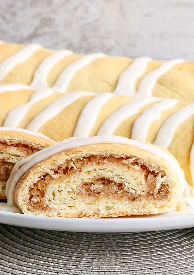 zoomed in image of a slice of nut roll on a white plate with a gray placemat under it