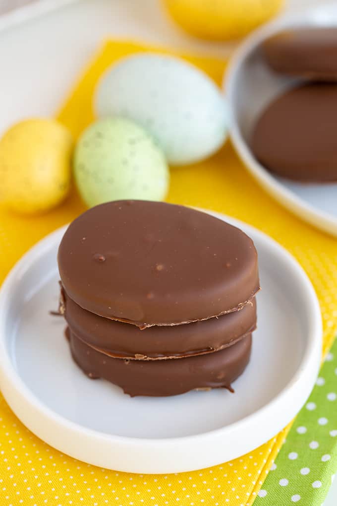 stack of pb eggs on a rimmed white plate with yellow linen under the plate