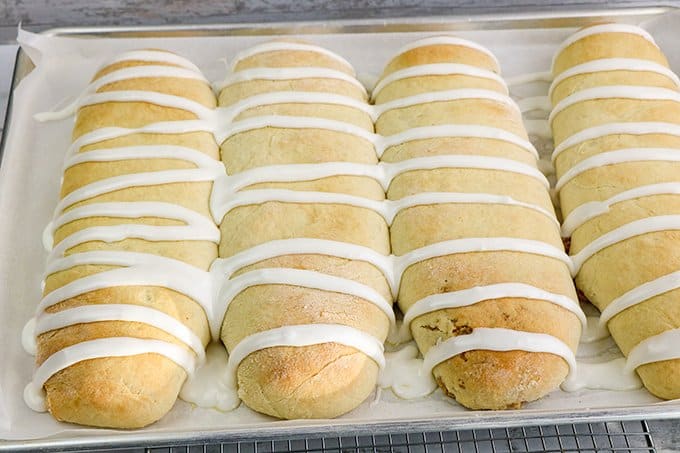 a sheet pan with four nut rolls on parchment paper