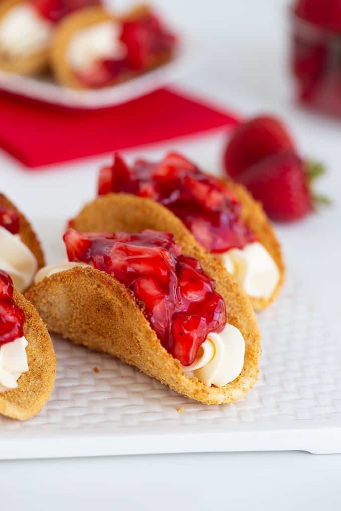 cheesecake tacos on a white cutting board on a white surface