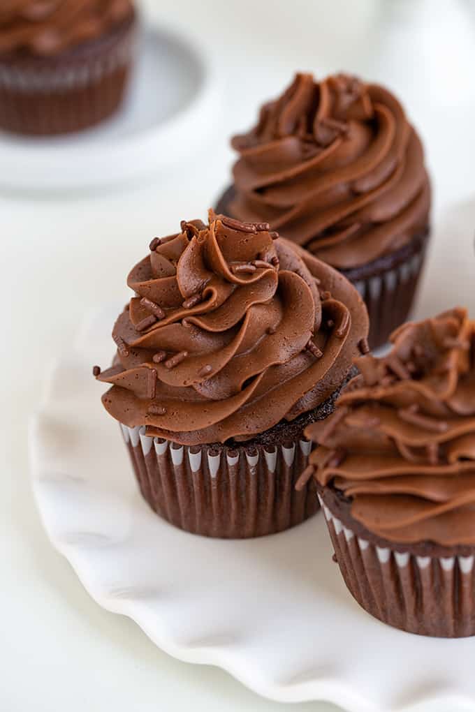 Cupcakes with swirls of frosting on a scalloped plate