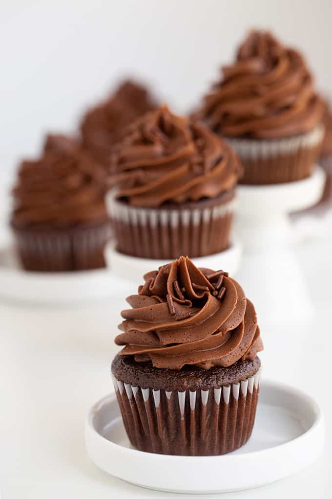 cupcakes on a small white plate with other cupcakes on small white cake stands