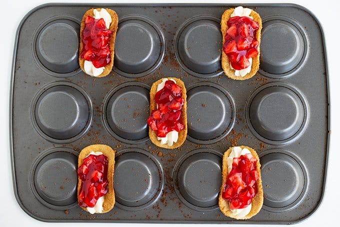 upside down cupcake pan holding 5 cheesecake tacos