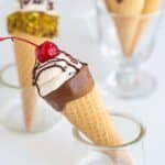 a cone propped in a white glass container on a white surface