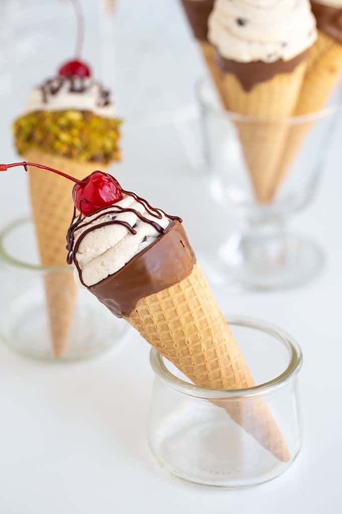 a cone propped in a white glass container on a white surface