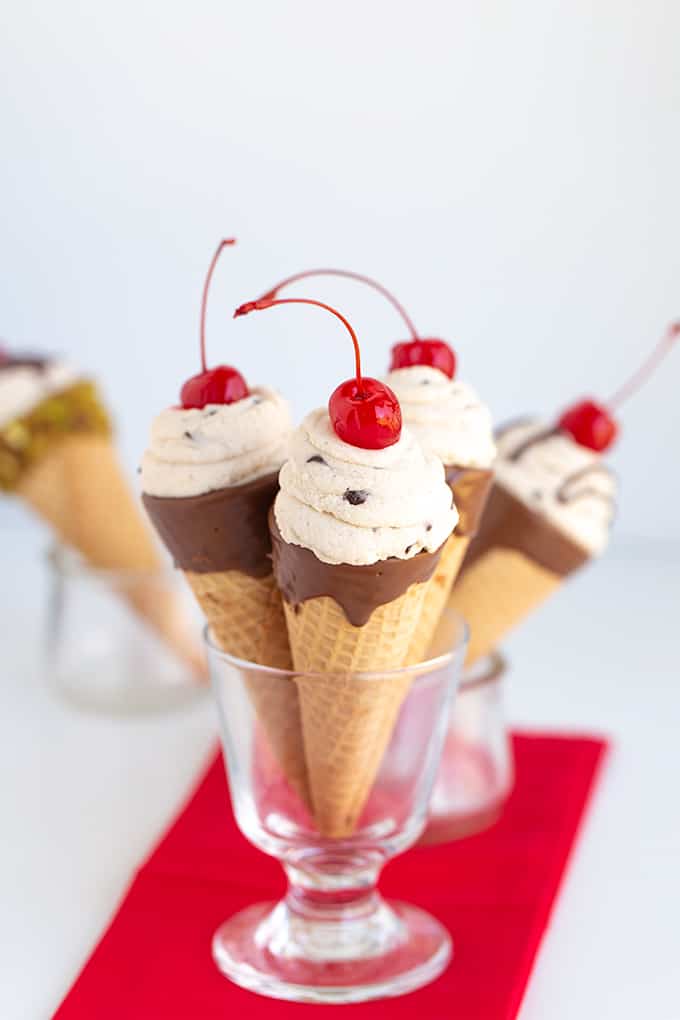 glass full of cannoli cones on a red linen on a white surface